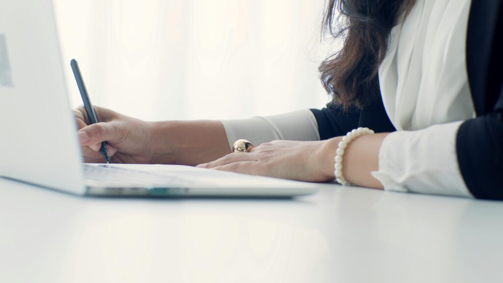 office-woman-writing-with-her-laptop-on-the-table