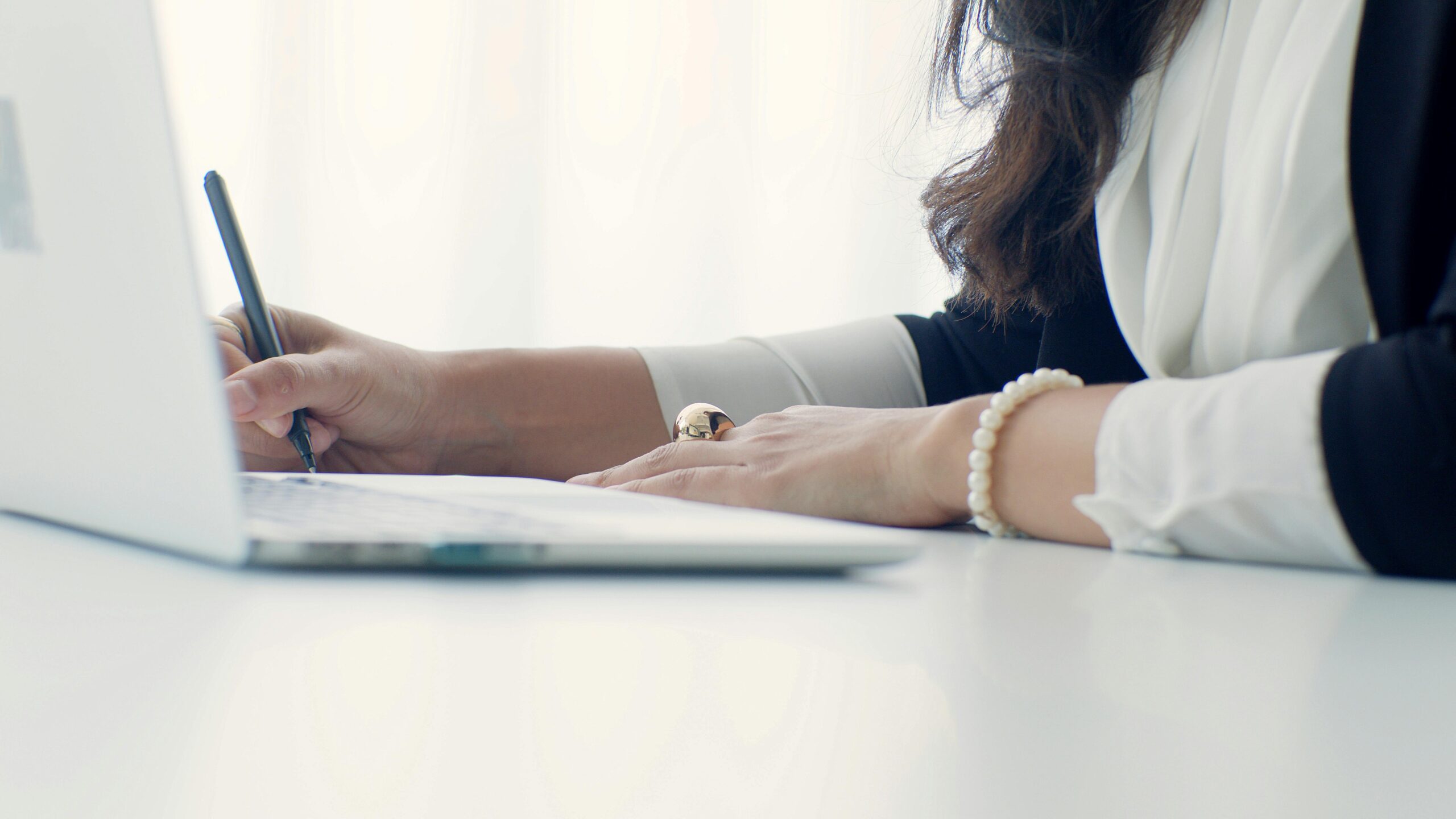 office-woman-writing-with-her-laptop-on-the-table