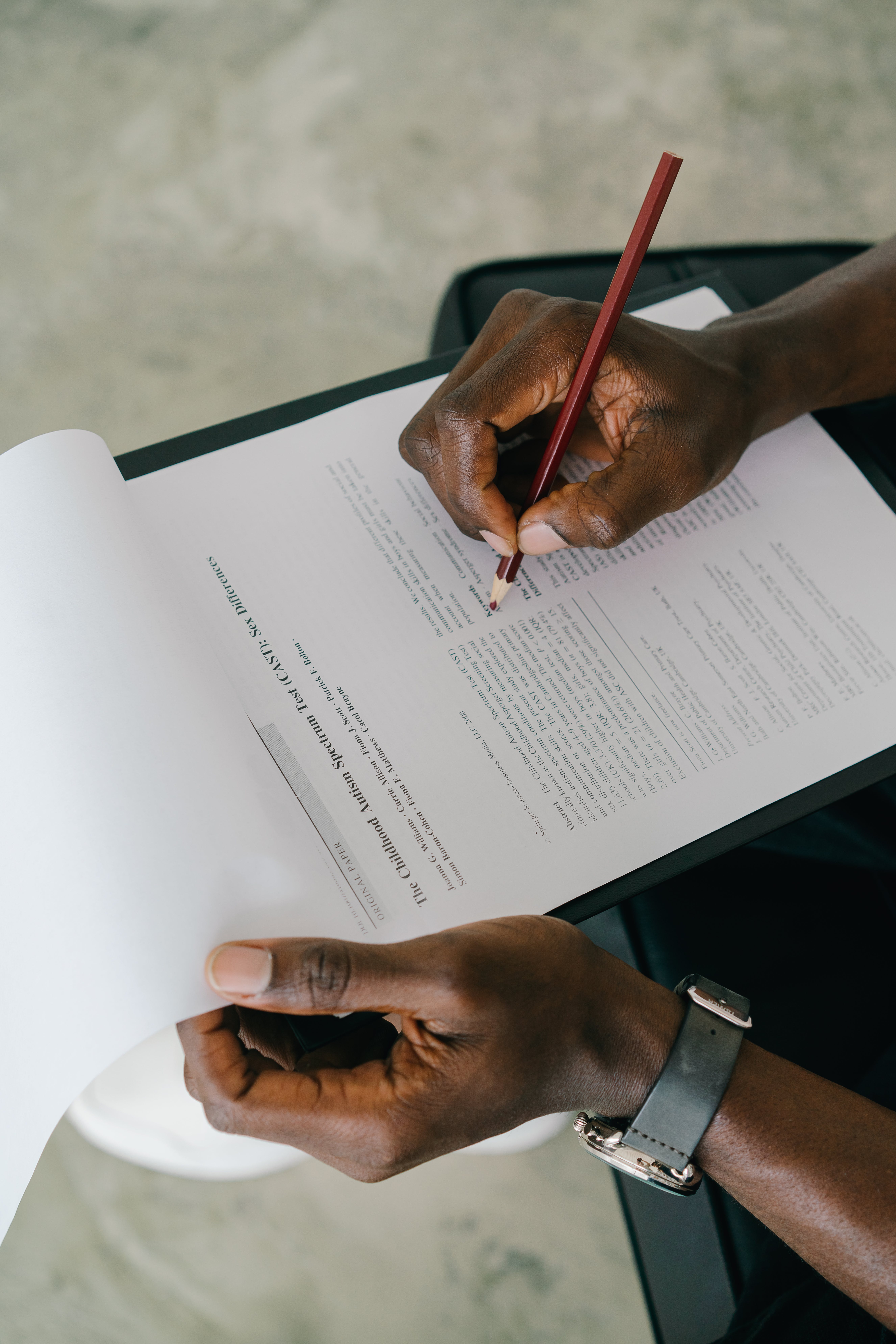 image of a hand writing on a paper document with brown pencil